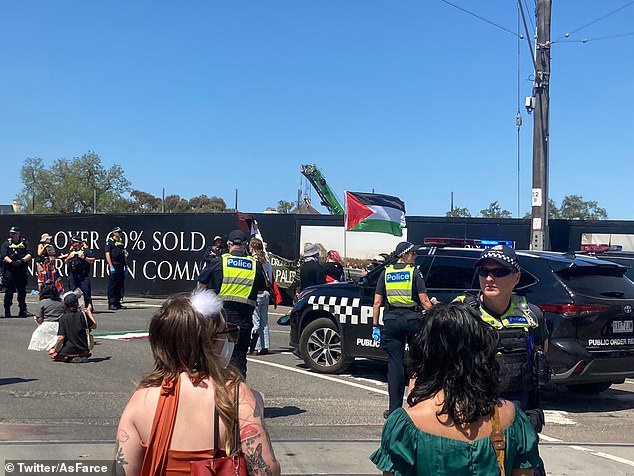 Police stand guard outside Flemington Racecourse as protesters gather