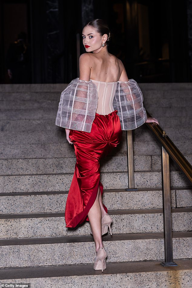 Stunning: She pulled her brunette locks back into a sleek and chic bun to show off a pair of dangling gemstone earrings