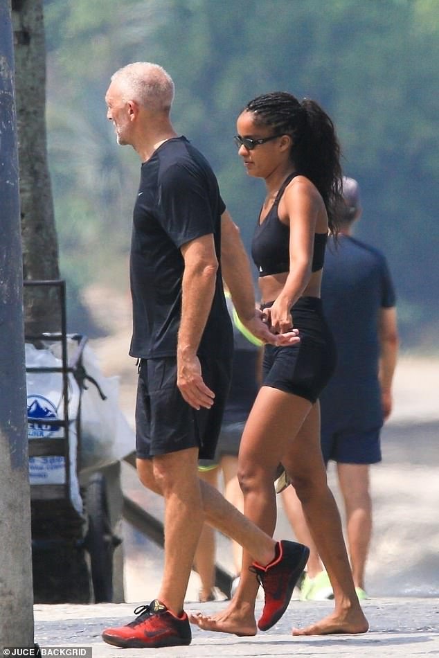 Sweet: The French actor, 56, and his new Brazilian girlfriend, 27, held hands during a sunny stroll along the beach