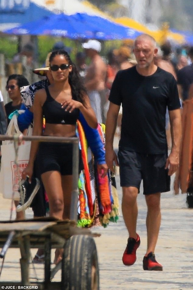 Looking hot: Narah showed off her washboard abs in a black crop top and cycling shorts as she went barefoot and wore her shoes during the walk