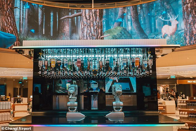 Passengers can grab a free cocktail from the airport's 'robot bartender', Toni, at the new two-level Lotte Duty Free Wines & Spirits store