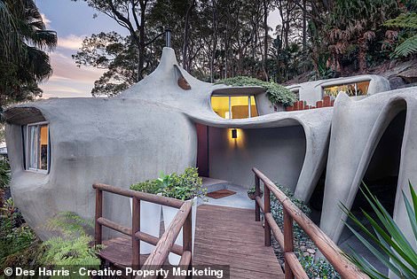 The unique home appears to 'defy gravity' with its 'gently curved contours' that 'ebb and flow like waves' thanks to the unique asymmetrical ferrocement structure