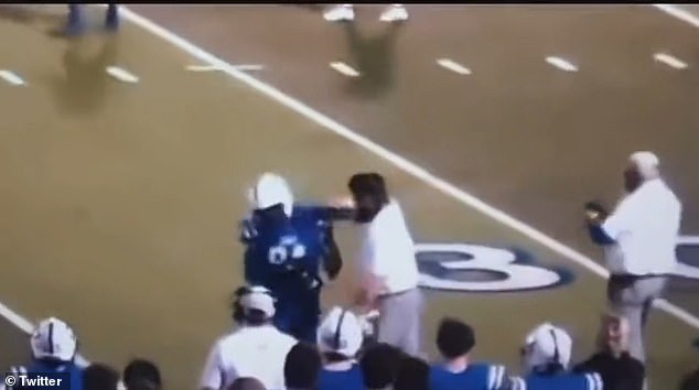 The clip shows the assistant coach yelling at the player before punching him in the helmet