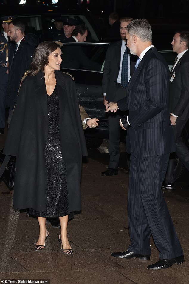 Letizia, 51, stunned in an all-black ensemble, with a sequin midi dress and strappy sandals, for the exhibition inauguration