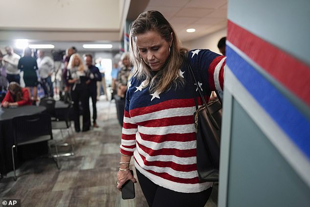 A woman bows her head during a prayer at a watch party for No. 1 opponents