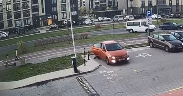 The next moment the car starts moving and hits the boy who is still standing on the asphalt behind the open door