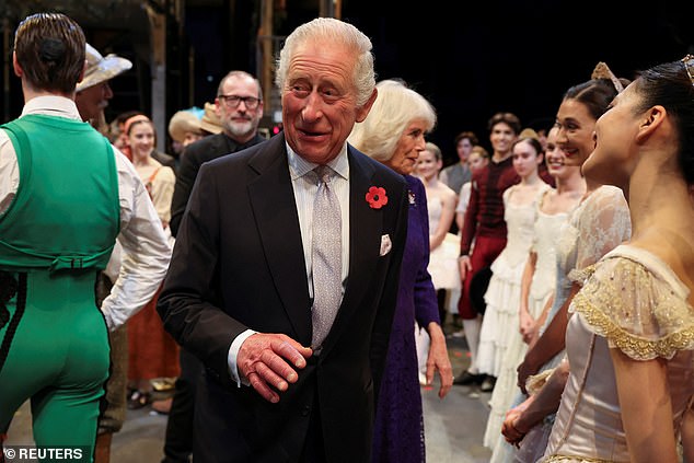 The king looked sharp in a suit and tie with a pocket square and a poppy on his lapel