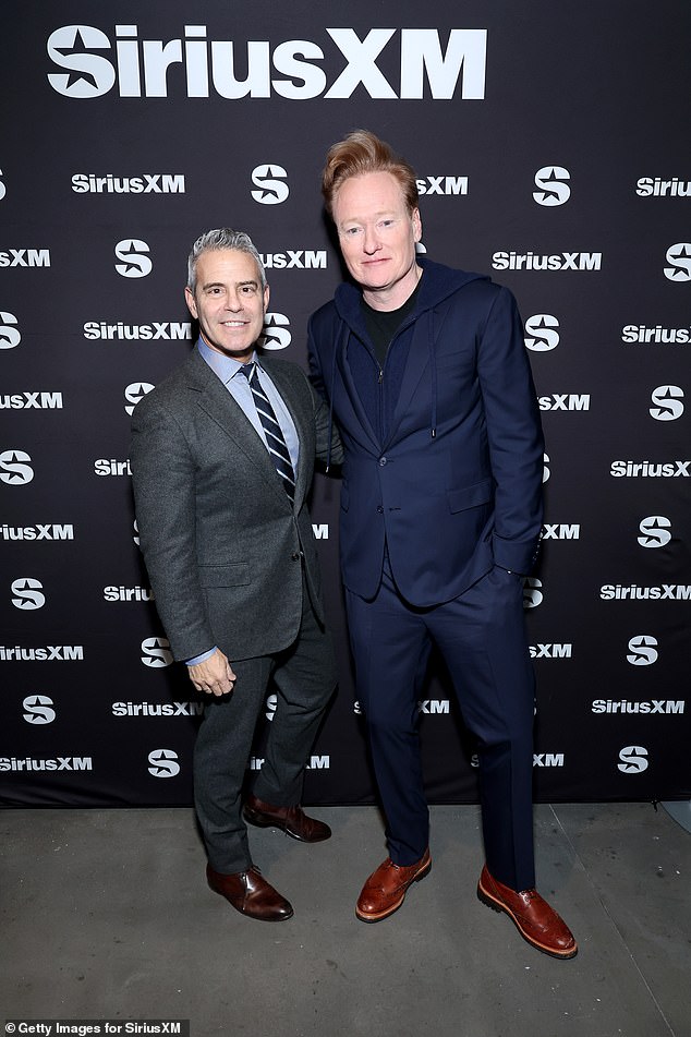 Sharp: Andy Cohen opted for a dark gray suit, with a blue button-up and a striped tie to complete the look;  pictured with Conan