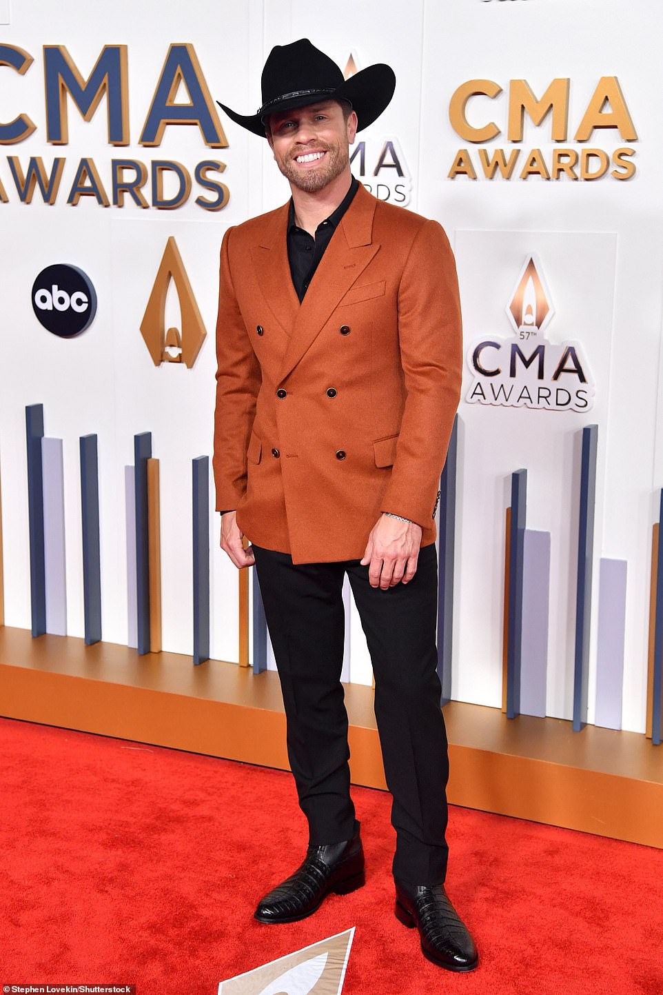 Country music's biggest night: Dustin Lynch looked handsome as he arrived on the red carpet in a burnt orange jacket, black cowboy hat and matching pants