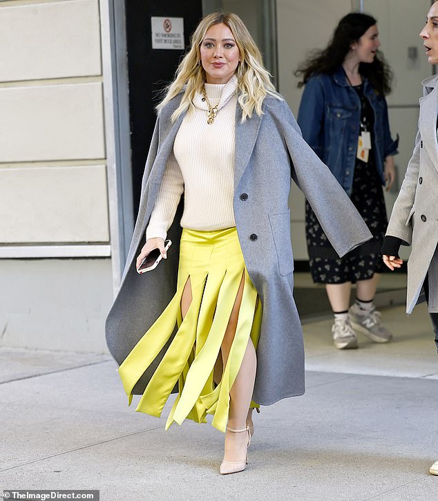 Author of children's books: she combined the unique skirt with a cream-colored sweater, a long gray woolen trench coat and nude heels