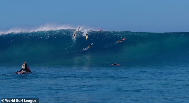 Enever (pictured center, with yellow surfboard) was launched into a monster 13.3 meter (or 43.6 foot) wave at the infamous Himalayan Fault on Hawaii's north coast and survived to tell the story