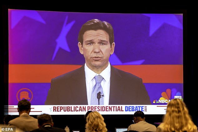 Journalists watch Florida Governor Ron DeSantis in the opening minutes of Wednesday night's GOP debate in Miami