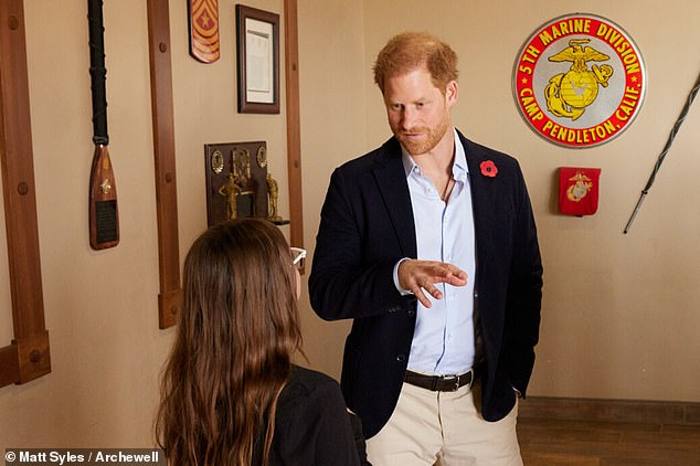 Prince Harry, wearing a Remembrance Day poppy in his lapel, is pictured chatting with a guest at Wednesday's event