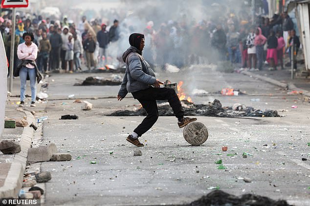 A protester blocks the streets with rocks and rubble during an ongoing strike by taxi companies against traffic authorities, in Msiphumelele, Cape Town, South Africa, August 8