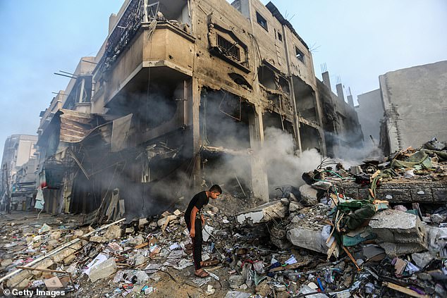 A youth searches buildings destroyed during Israeli airstrikes in the southern Gaza Strip on November 8, 2023 in Khan Yunis, Gaza