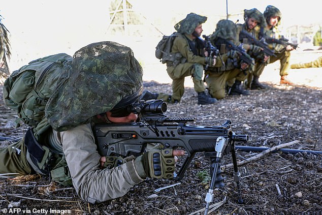 Israeli soldiers hold a position as troops train in the Upper Galilee region of northern Israel, near the border with Lebanon, on November 8, 2023