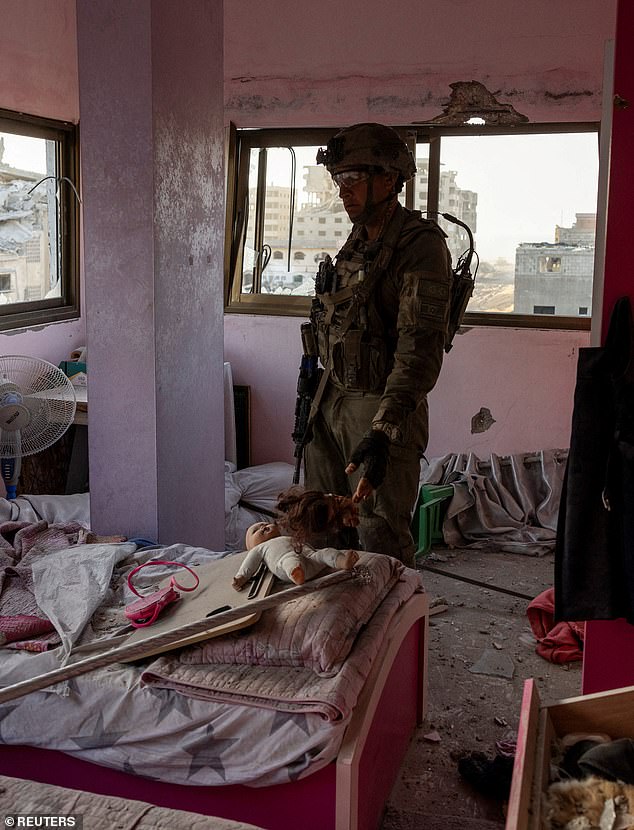 Lt. Col. Ido stands in a damaged bedroom, which he claims is above a workshop used for weapons production in a residential building amid the ongoing ground invasion against the Palestinian Islamist group Hamas in the northern Gaza Strip