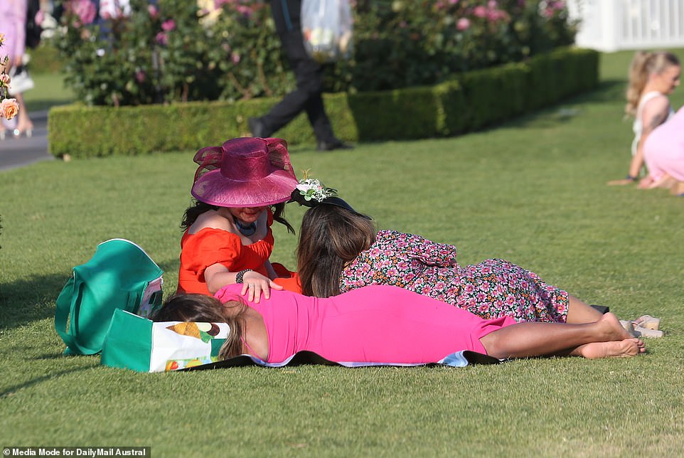 The woman in the big pink hat appears to be checking out her friend in the bright pink dress