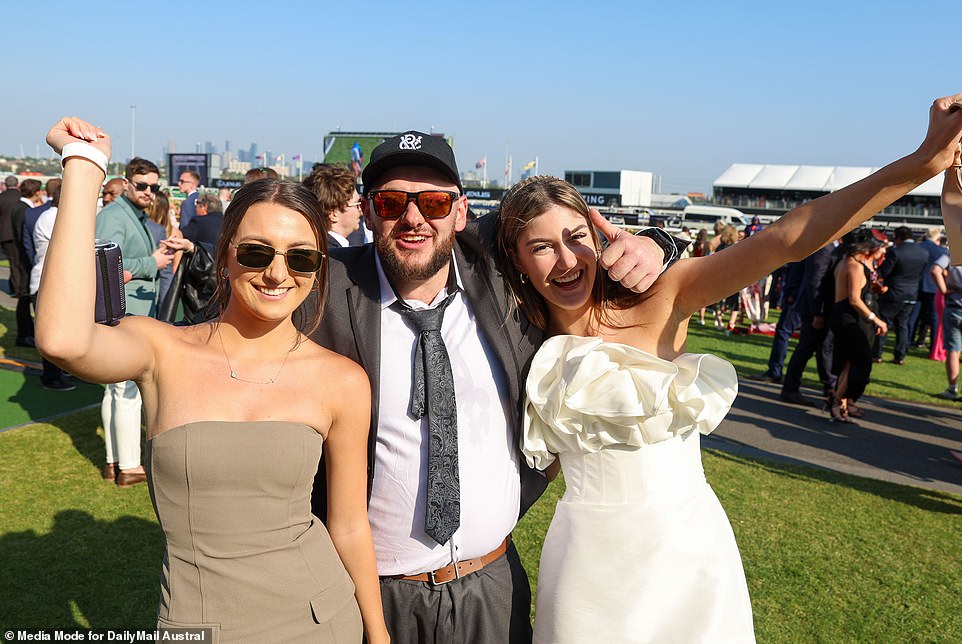 The man in the baseball cap and ill-fitting shirt doesn't care that he's the third best dressed in this photo