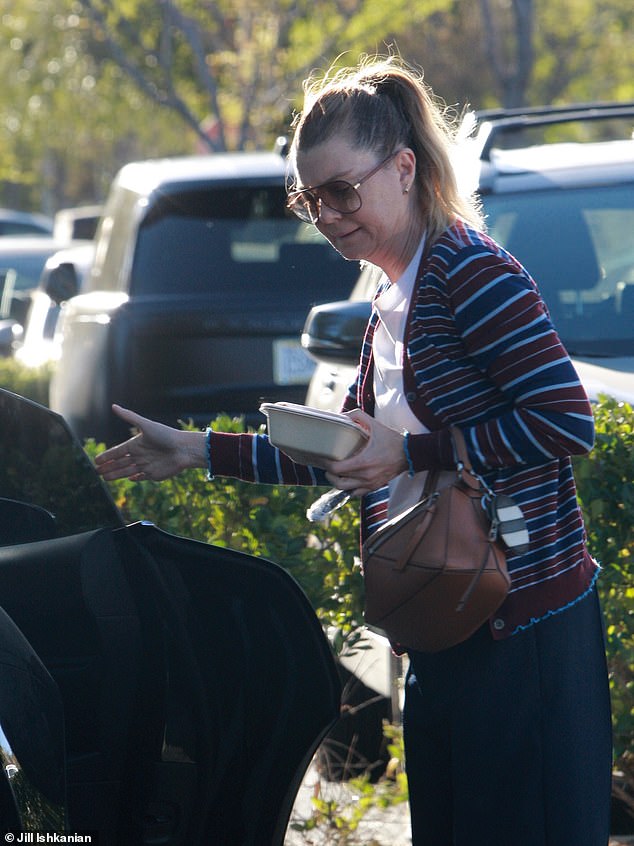 Her hair was tied back in a tight ponytail, she wore a white T-shirt, a striped sweater, blue slacks and white sneakers