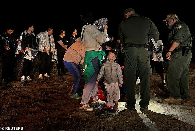 Anni Ren, a two-year-old girl from China, stands next to her mother as dozens of Chinese migrants are registered after crossing the Rio Grande in March