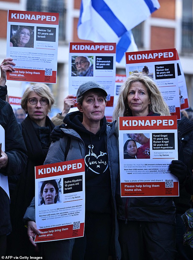 Posters featuring kidnapped Israeli Dafna Elyakim and Israeli-Argentinians Yuval and Ronan Engel are seen as people gather outside the Qatari embassy in London on October 29, 2023