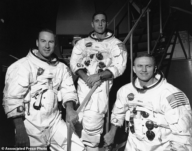 Apollo 8 astronauts, from left to right, James Lovell, command module pilot;  William Anders, lunar module pilot;  and Frank Borman, commander;  stand in front of the mission simulator prior to training for their planned six-day lunar orbital mission at the Kennedy Space Center in Florida