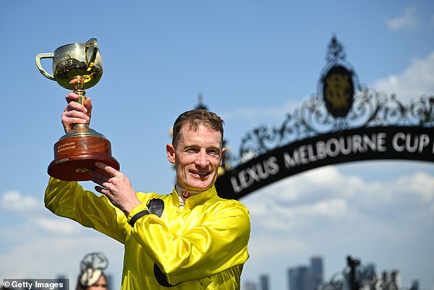 Melbourne Cup-winning jockey Mark Zahra is pictured on Tuesday holding the trophy from the race that stops a nation