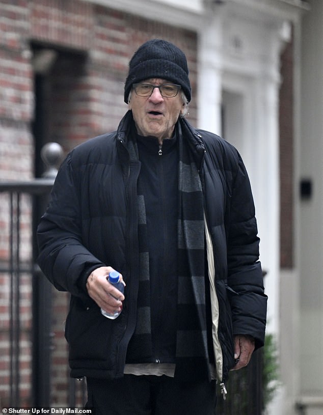 De Niro wore an all-black ensemble with a sweater, a large overcoat and a scarf