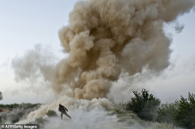 A U.S. Marine from the 2nd Marine Expeditionary Brigade flees to safety after an IED blast in the Garmsir district of Helmand Province in Afghanistan on July 13, 2009. Two U.S. Marines were killed when the explosion occurred as they attempted to establish a route to the Taliban to free.  heartland