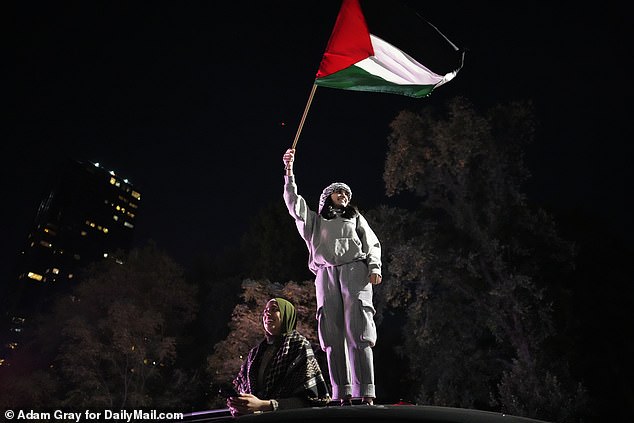 A woman is seen on top of a car during Friday's protest in Manhattan