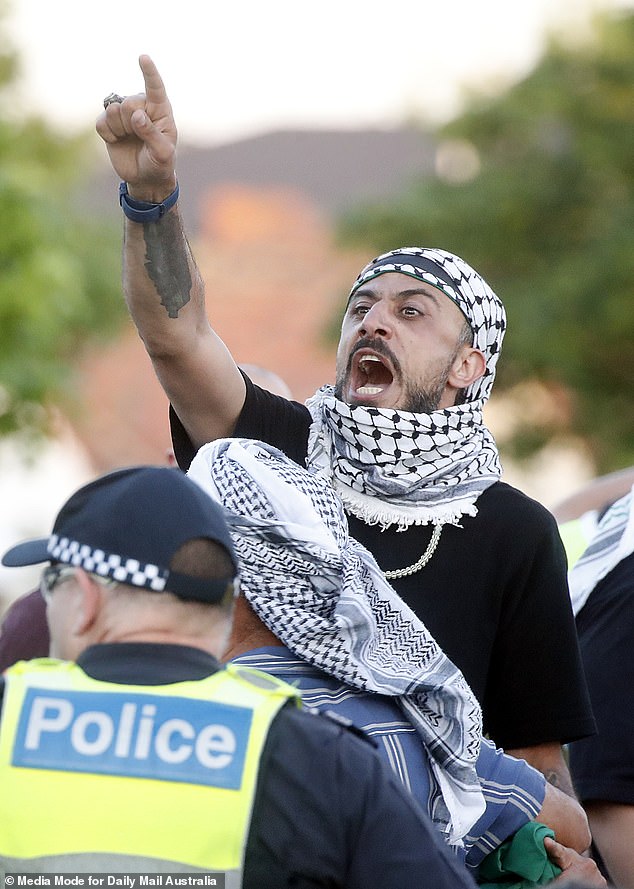 Protesters can be seen in Caulfield on Friday evening