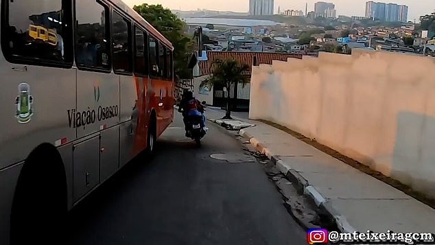 Despite the nail-biting near misses, the officer manages to keep following the lead rider's tail, while he and the passenger regularly turn around in shock to see the police still chasing them.