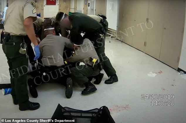 One of the videos shows a person on the ground bleeding and groaning, and officers use the WRAP device to subdue him