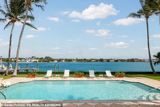 The backyard pool of the mansion (pictured) is surrounded by palm trees and overlooks Lake Worth