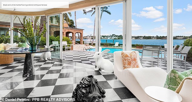 The room right next to the pool (pictured) is scaled with black and white marble tile floors and large glass pocket windows