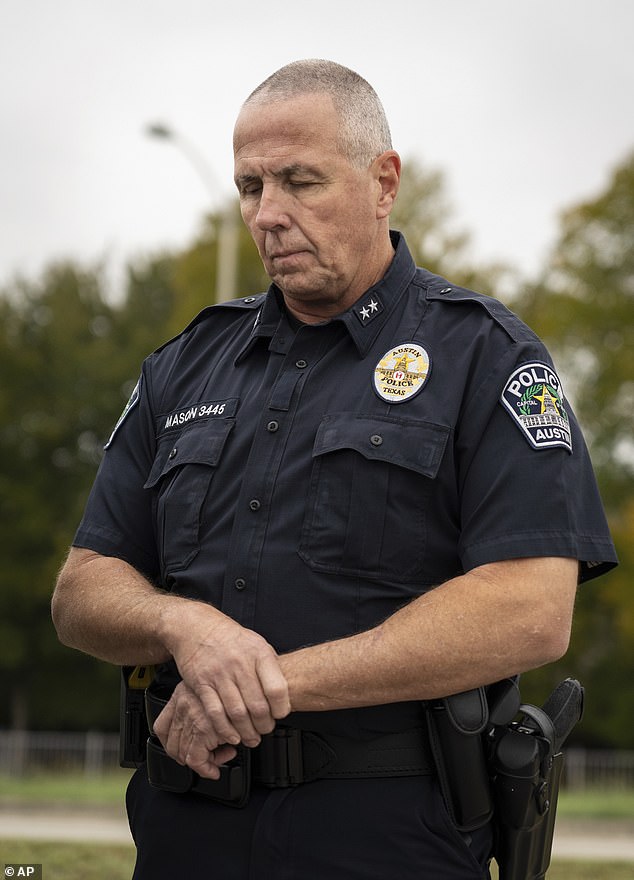 An officer bows his head as interim Austin Police Chief Robin Henderson addresses the media