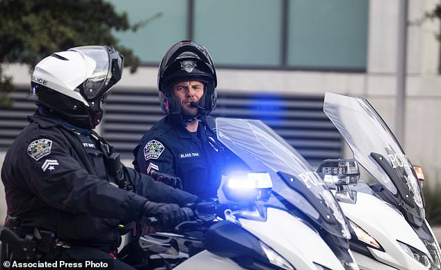 Austin Police Department officers are pictured riding in a procession to remember the fallen officer