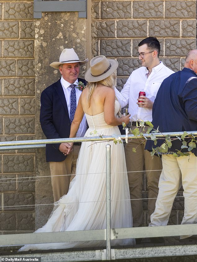 The newlyweds held hands as they spoke to guests at their wedding on Sunday (pictured)