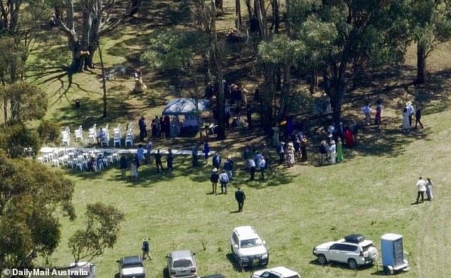 Before the ceremony, guests could be seen standing in the shade.  One portable toilet was attached to the rear of one vehicle (photo)