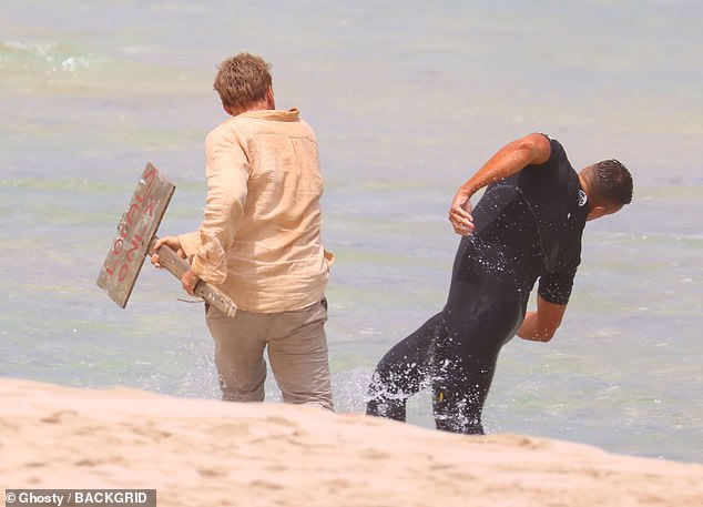 The California native was then seen picking up a sign on the beach that read 