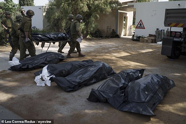 In the kibbutz Kfar Aza, Israeli soldiers treat the dead after the October 7 atrocities