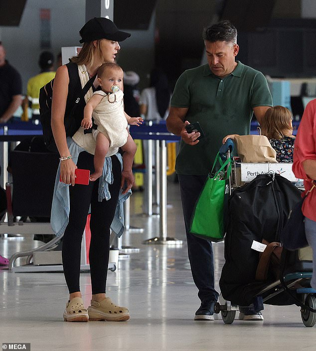 The Backyard Blitz star was pushing a cart full of luggage and bags with girlfriend Ameka Jane, two-year-old daughter Beau and newborn son Nash by his side (all pictured)