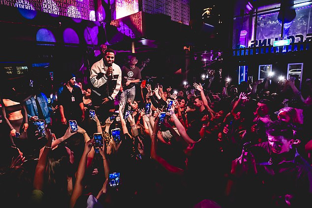 He wasn't afraid to get up close and personal with the crowd as he rocked a black and white ensemble with a black and white racing jacket.