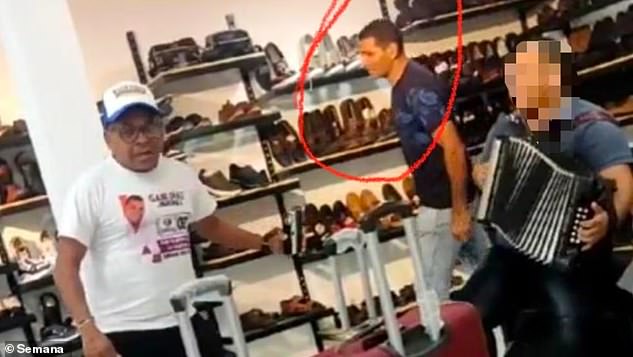 A chilling image released by police in Colombia shows one of those arrested 'stalking' Luis Manuel Diaz in a shoe store as they build up a picture of his movements