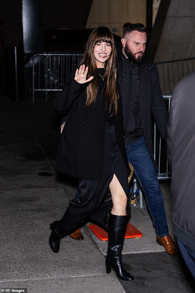 Gorgeous: While Dakota looked effortlessly chic in a black split denim skirt, paired with knee-high leather boots