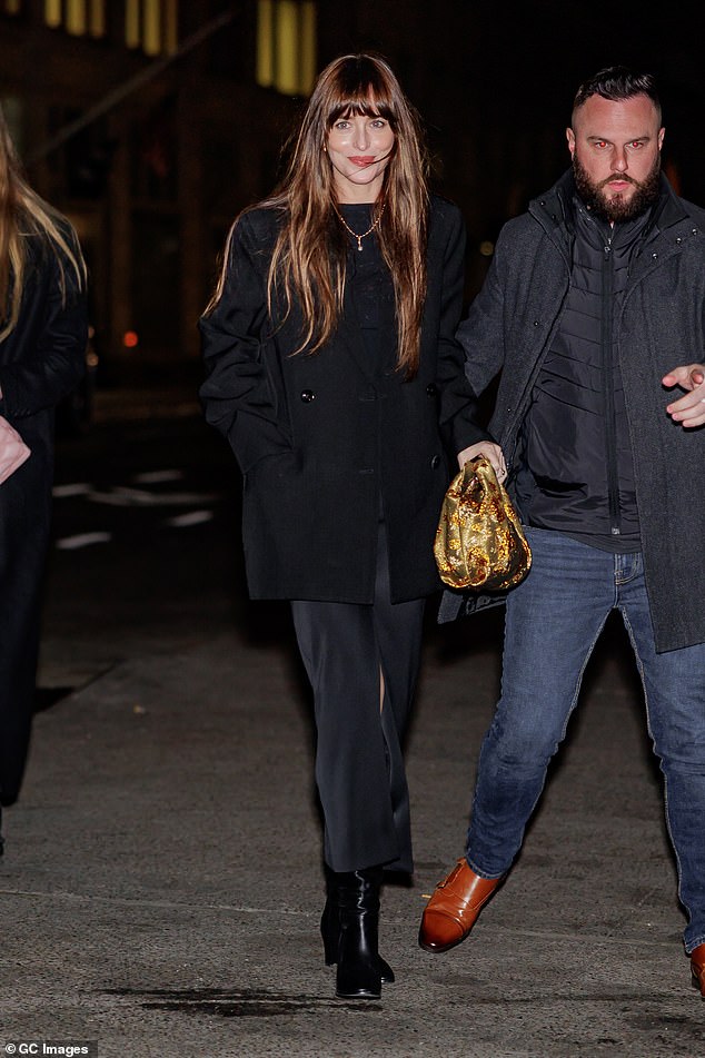 Wow: Dakota seemed happy and relaxed as she waved to the cameras and was assisted by security guards