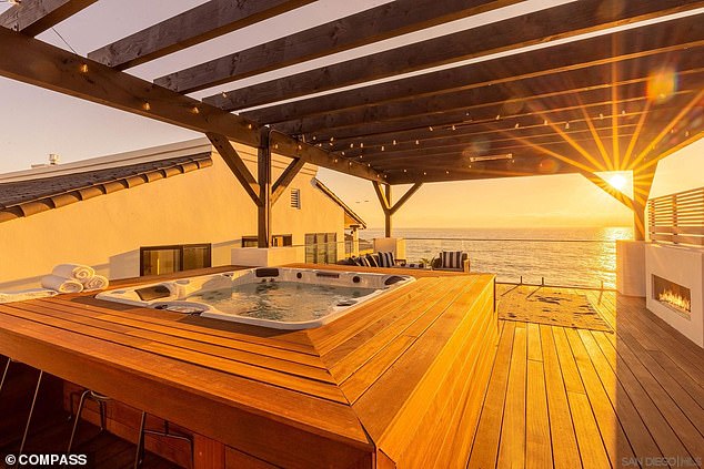 The private spa features a jacuzzi and a glass-paneled balcony with sunset views