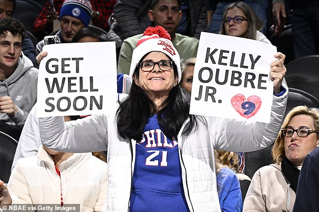 A Sixers fan holds up a sign in support of Oubre Jr., who is facing a significant injury