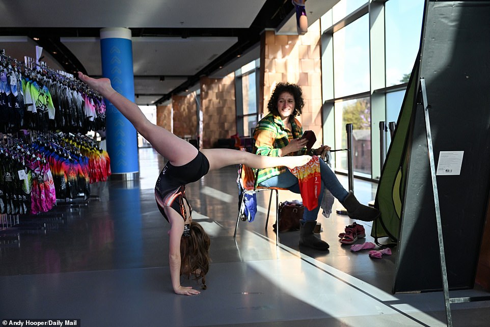 A performer at the competition begins warming up in the halls by performing a headstand prior to her event